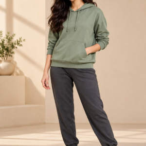 Woman wearing a sage-green hoodie and charcoal joggers